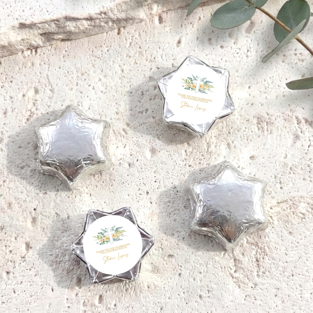 Silver foil-covered chocolate stars with personalised circular cross label on each star wrapper