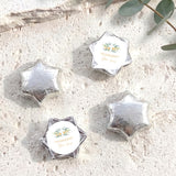 Silver foil-covered chocolate stars with personalised circular cross label on each star wrapper