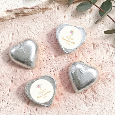 Silver foil-covered chocolate hearts with round label and floral cross design