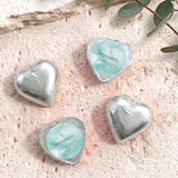 Silver foil heart chocolates with blue center label and gold cross