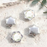 Silver foil-covered chocolate star candies with personalized label on hexagon star packs