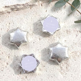 Silver foil-covered chocolate stars with a small white cross on the wrapper center