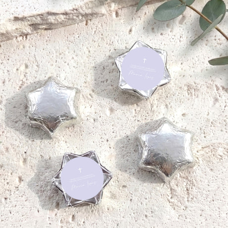 Silver foil-covered chocolate stars with white round labels and a small cross