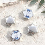Silver foil-wrapped chocolate stars with printed floral confirmation label, four pieces.