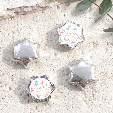 Silver foil-covered chocolate stars with a round personalised label on one star