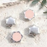 Silver foil-covered chocolate star sweets with blank round labels