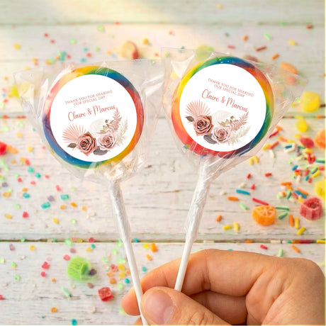 Rainbow-edge boho personalised lollipops with “Claire & Marcus” on round white labels