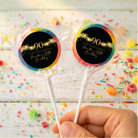 90th birthday black-and-gold star personalized lollipops with rainbow border, two in hand