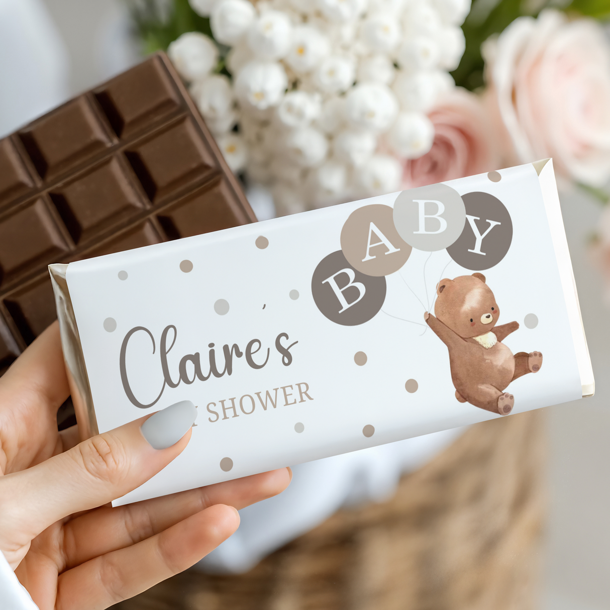 Baby shower chocolate bar wrapper held in hand, Claire's name, bear and balloons