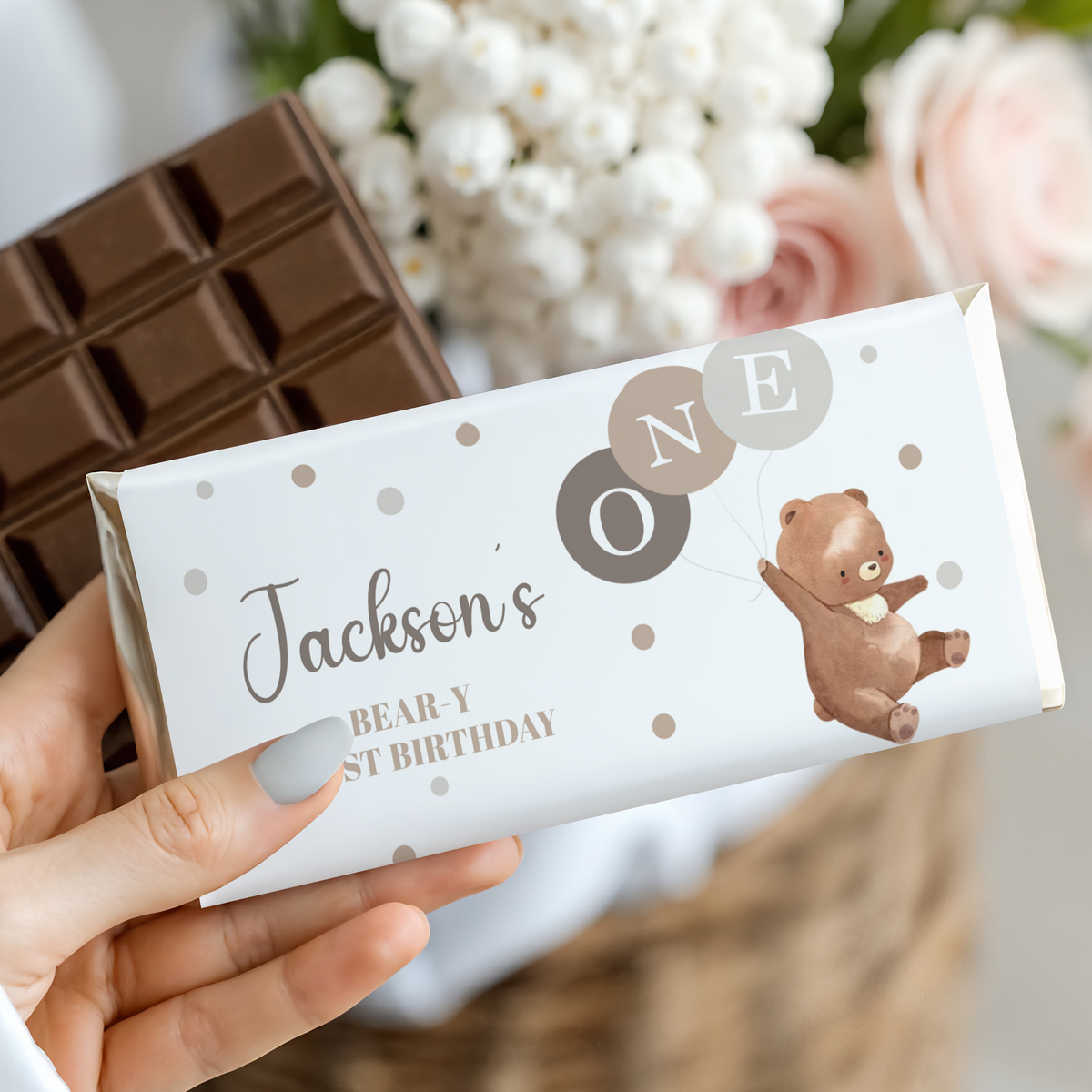 Bear-themed chocolate bar wrapper held in hand, polka dots and name