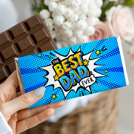 Blue "The Best Dad Ever" comic chocolate bar held in hand with starburst artwork