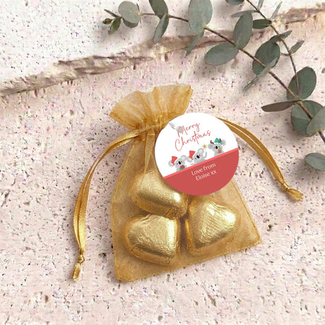 Gold organza gift bag with gold heart-shaped chocolates and a round gift tag