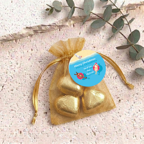 Gold metallic heart-shaped treat in gold organza drawstring bag with blue round tag