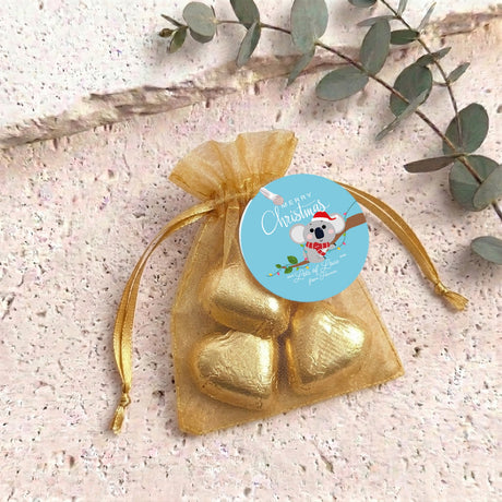 Gold heart chocolates in sheer golden organza drawstring gift bag with round label