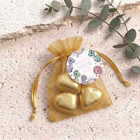 Sheer organza drawstring bag with metallic gold heart candies on a printed tag