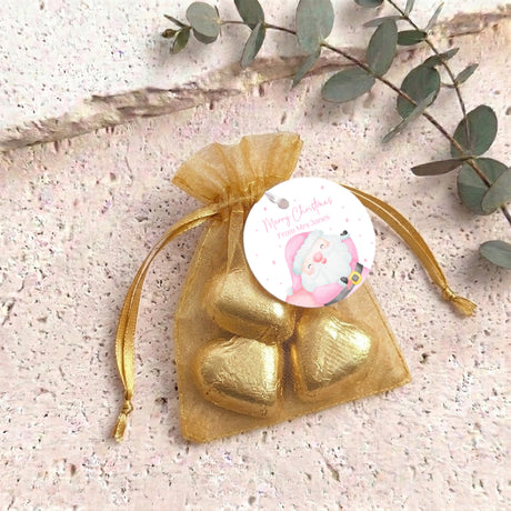 Gold-colored organza gift bag with heart-shaped foil candies and round Santa label