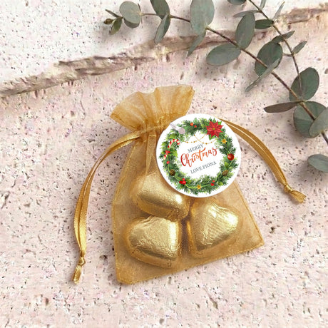 Personalised organza gift bag with gold heart-shaped chocolates and round Christmas label