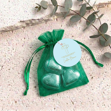 Green heart chocolates in green sheer organza gift bag with round personalized label.