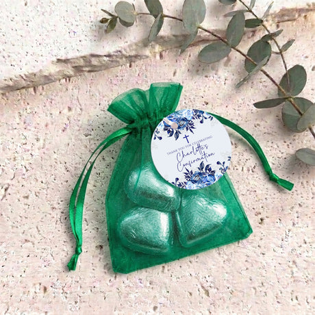 Green organza drawstring bag with green foil heart chocolates and a round blue label