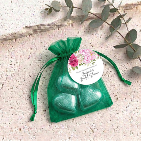 Green organza gift bag with green heart chocolates and floral round label