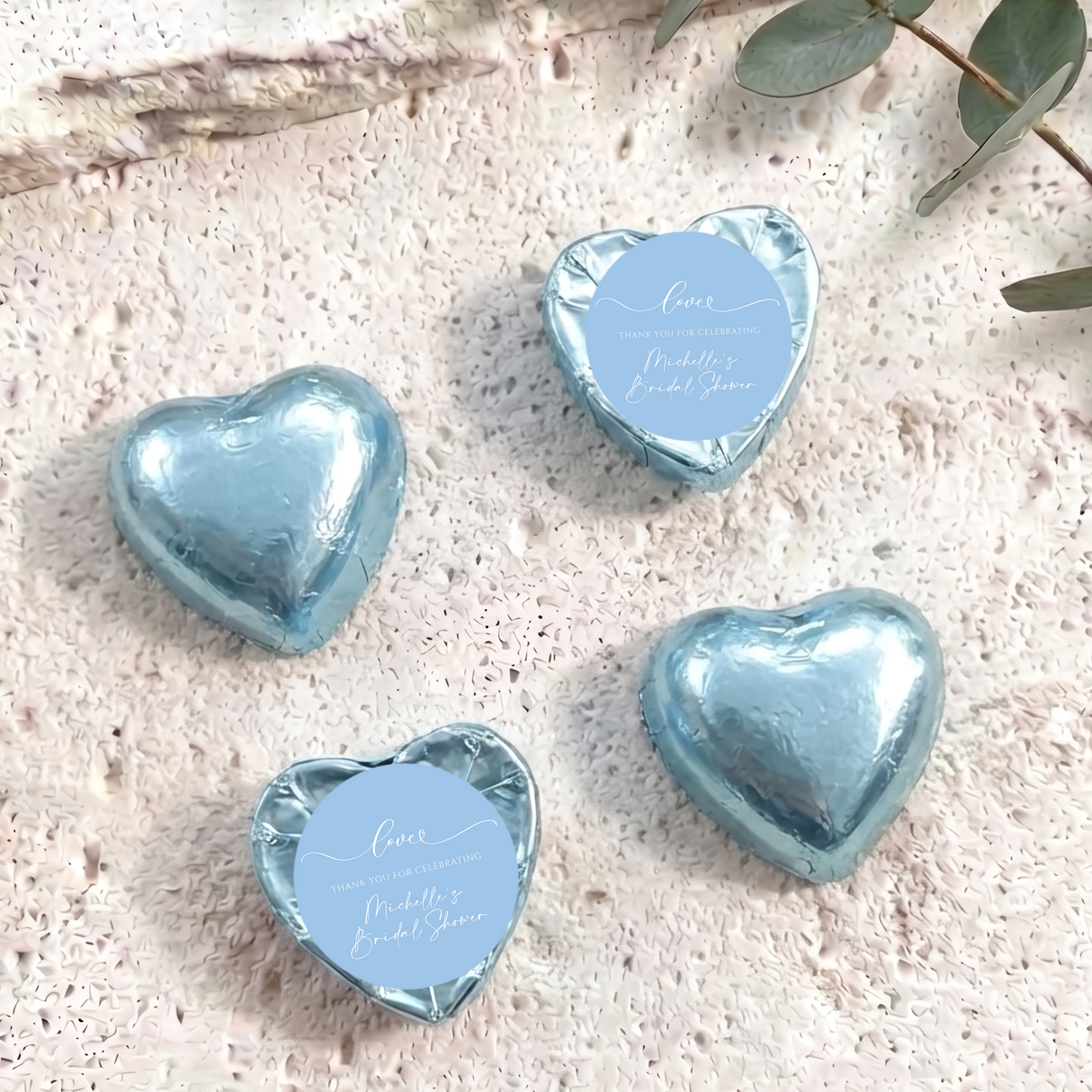 Blue foil-covered chocolate hearts with circular thank-you bridal shower label
