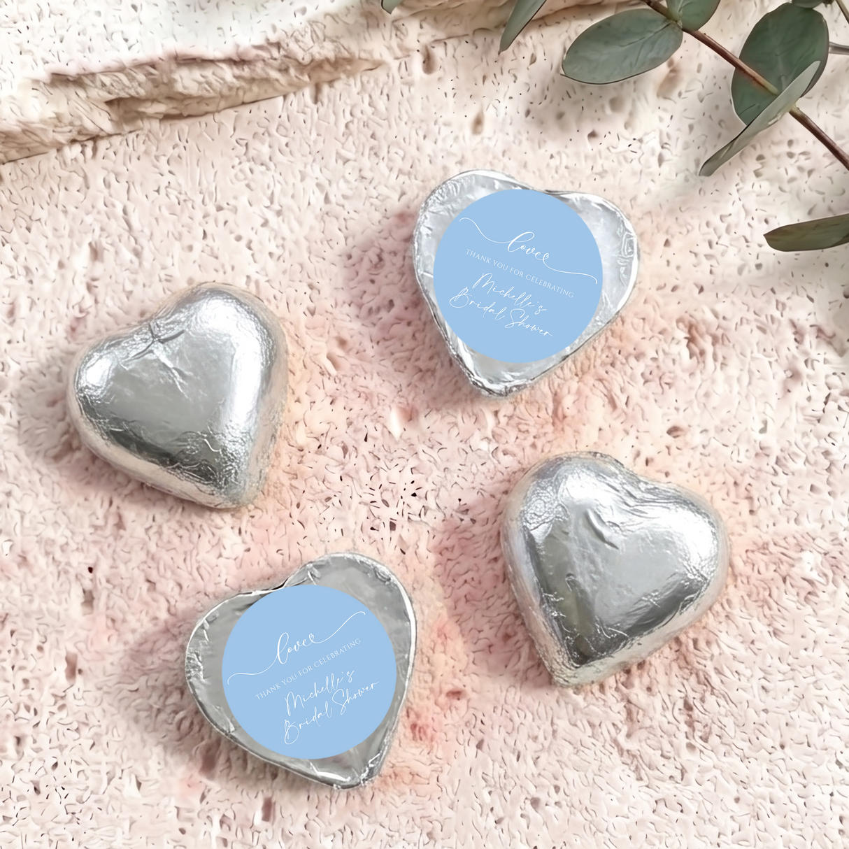 Silver foil-covered chocolate hearts with circular thank-you bridal shower label