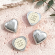Foil-covered silver chocolate hearts with round personalized logo label