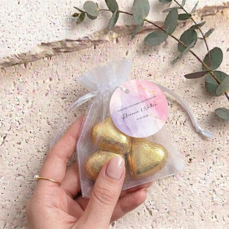 Personalised organza wedding favor bag with gold heart chocolates and round label