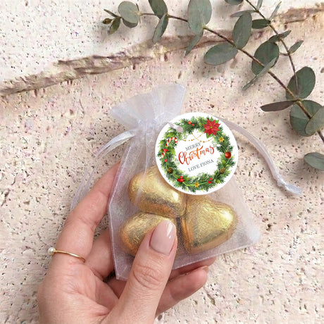 Personalised organza gift bag with gold heart-shaped chocolates and round Christmas label