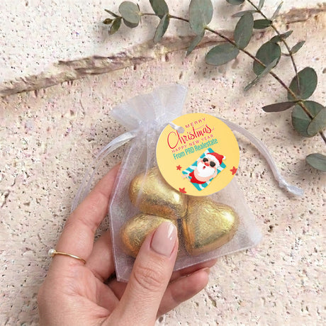 Gold metallic heart chocolates in sheer white organza gift bag with drawstring tag