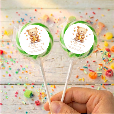 Personalised baby shower lollipops with teddy bear labels on green discs, clear wrap