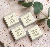 Four mini personalized chocolates with silver-foiled ends and “YOUR LOGO HERE” labels on cream wrappers