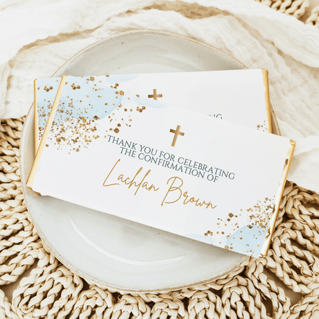 Custom confirmation chocolate bars with pastel blue and gold speckled wrappers, gold cross accents.