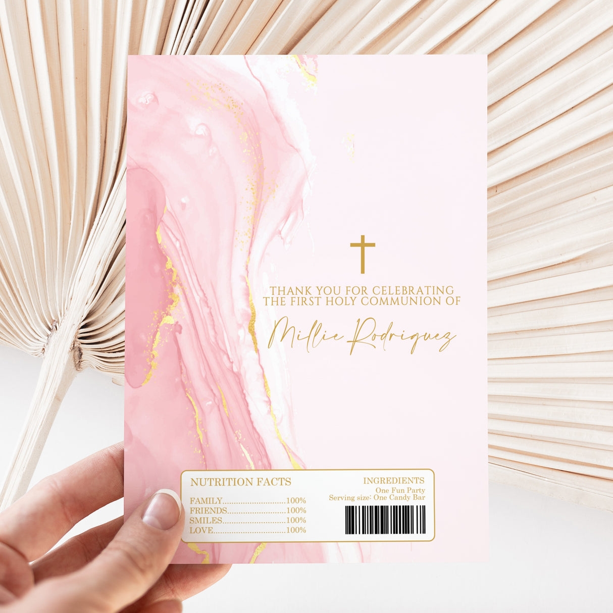 Pink & gold marble Holy Communion chocolate wrapper with gold cross, held up, nutrition panel