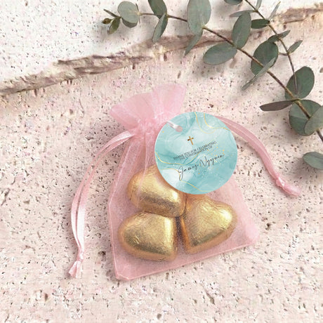 Personalised organza gift bag with chocolate hearts, pale pink organza pouch and gold heart chocolates.