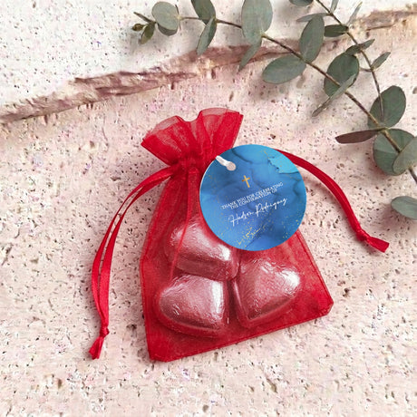 Personalised organza confirmation bag with red foil heart chocolates and blue name tag