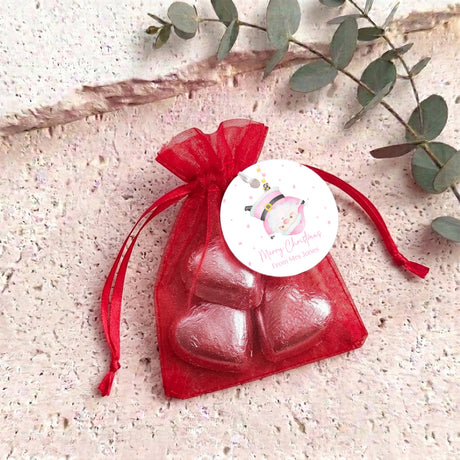 Red organza gift bag with glossy red heart chocolates and bow ribbon top