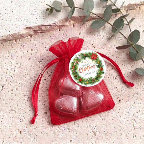 Personalised organza gift bag with red heart-shaped chocolates and round Christmas label