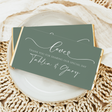 Sage green chocolate bar wrapper with white cursive text and scalloped ends