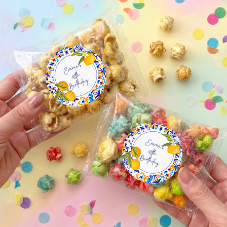 Clear popcorn bags with round blue floral labels and personalized birthday text