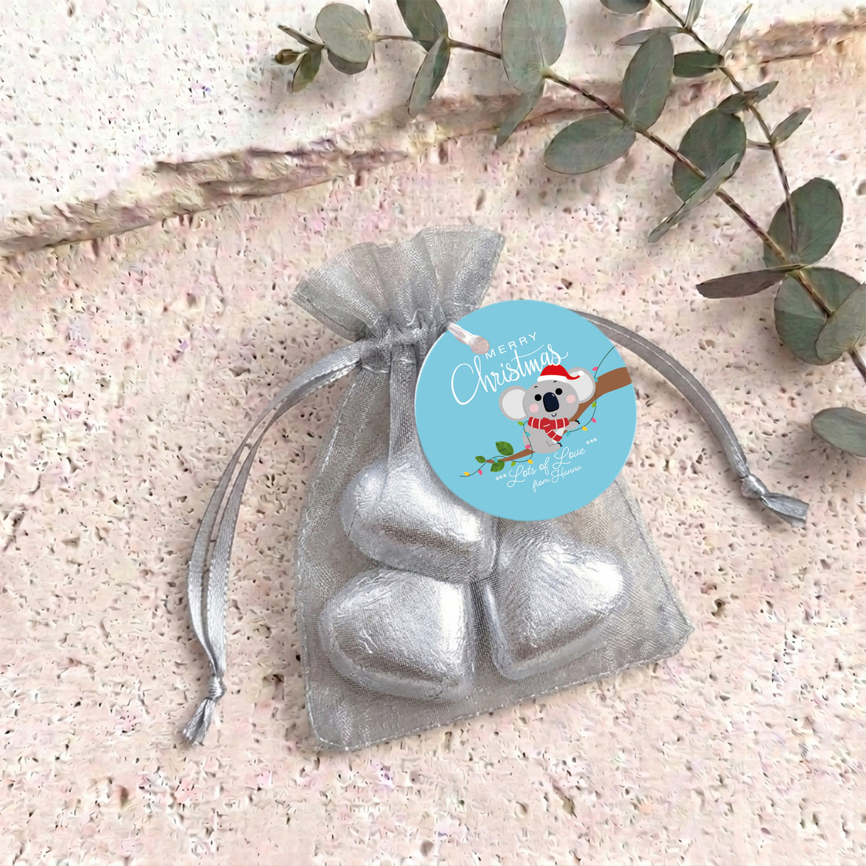 Silver heart chocolates in sheer grey organza drawstring gift bag with round label