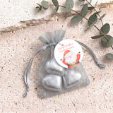 Organza gift bag with silver heart-shaped chocolates and gray pull-tie ribbon