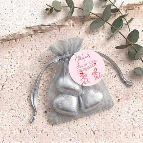 Silver metallic organza gift bag with drawstring, filled with heart-shaped chocolates