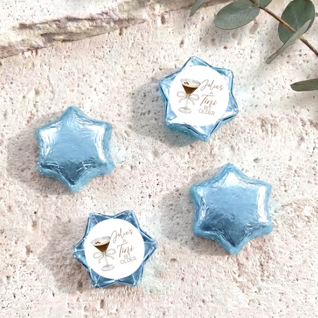 Light blue foil-covered chocolate star sweets with a personalized label on top