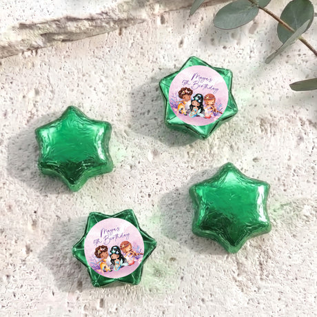 Green foil-covered chocolate stars, with a colorful mermaid birthday label star