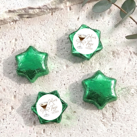 Green foil-covered chocolate star sweets with a personalized label on top