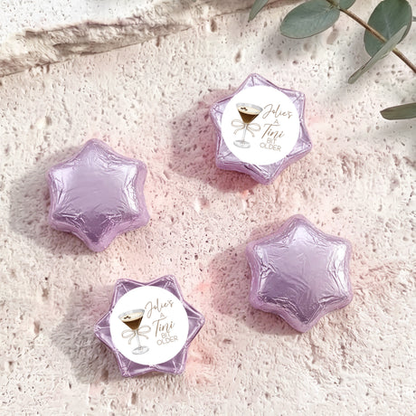 Lilac/purple foil-covered chocolate star sweets with a personalized label on top