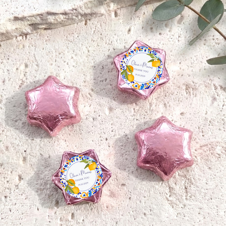 Pink foil-covered chocolate stars with round personalized label medallion