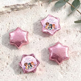 Pink foil-covered chocolate stars, with a colorful mermaid birthday label star
