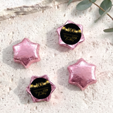Pink foil-covered chocolate star sweets with a 100th birthday printed center